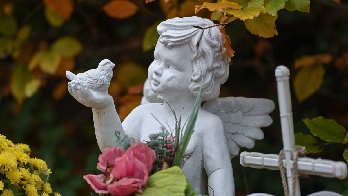 Engelsfigur, Putte, Friedhof, Grabkreuz, Blumen, Hintergrund