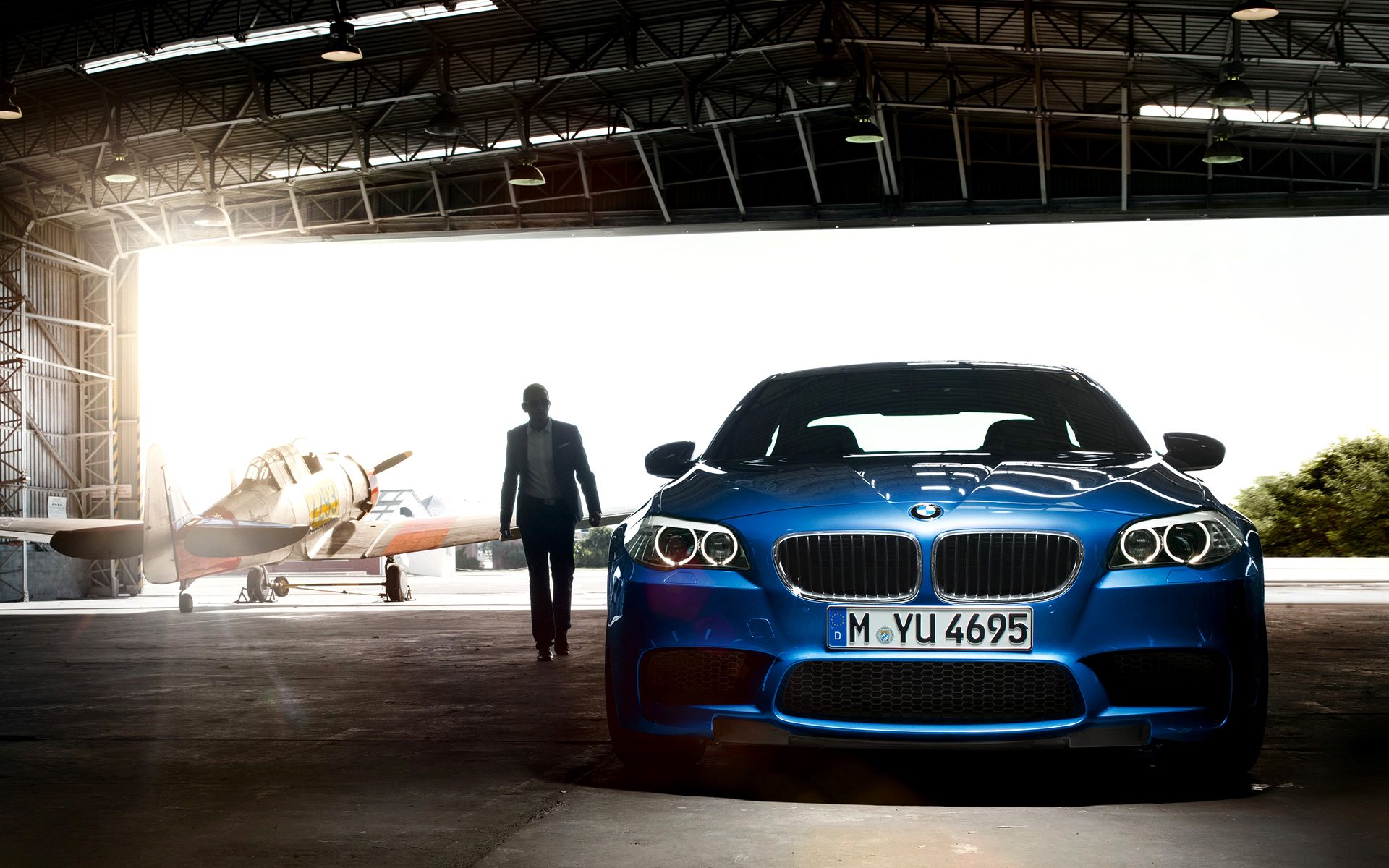 BMW M5 (F10), Blaues Auto, Hangar, Flugzeug, Mann, 16:10, Full-HD-Hintergrundbild für den Desktop