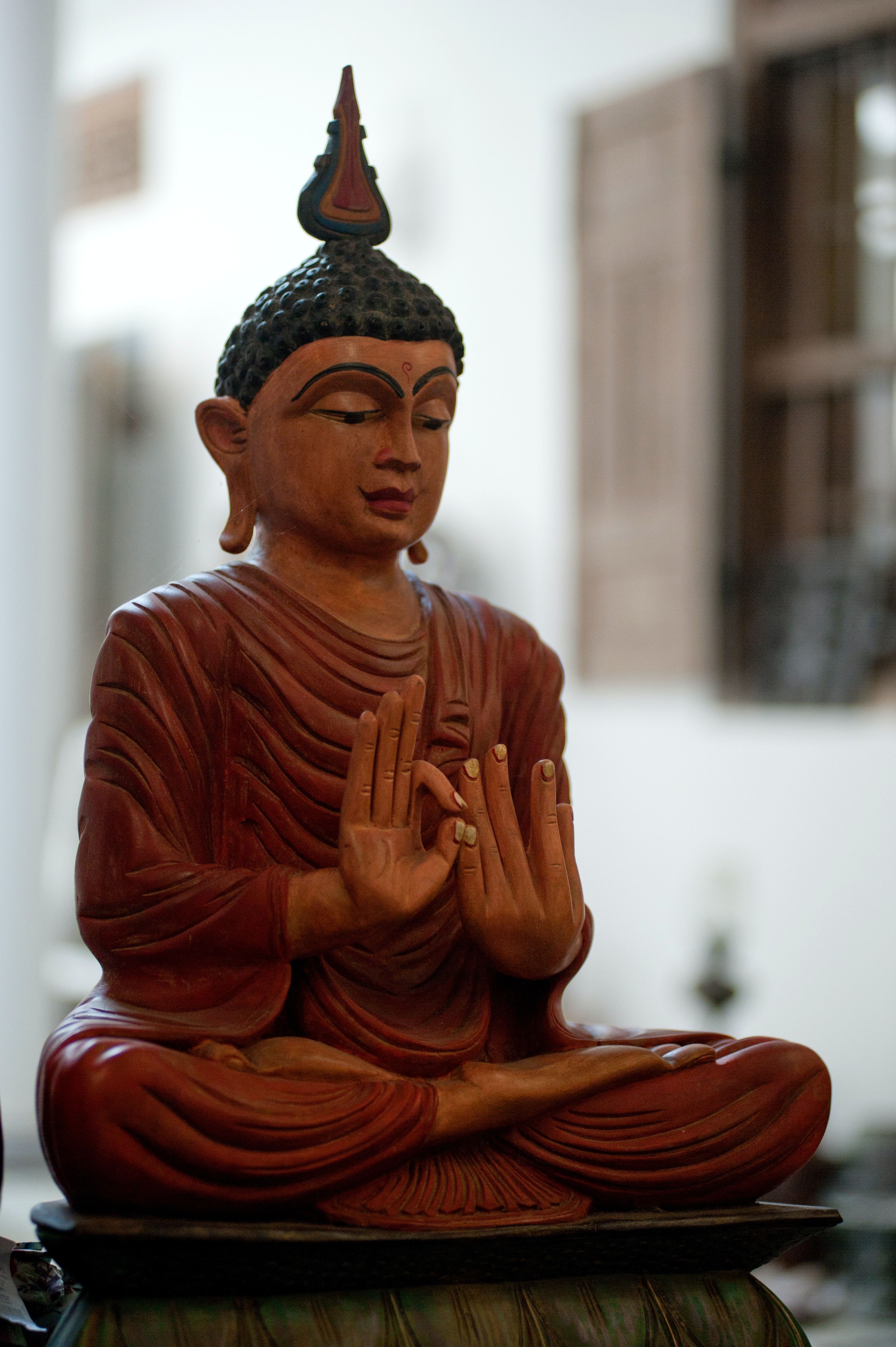 Buddha-Figur, Rote Robe, Gebetshände, Unschärfe, Warme Töne, QHD+, Handy-Hintergrundbild