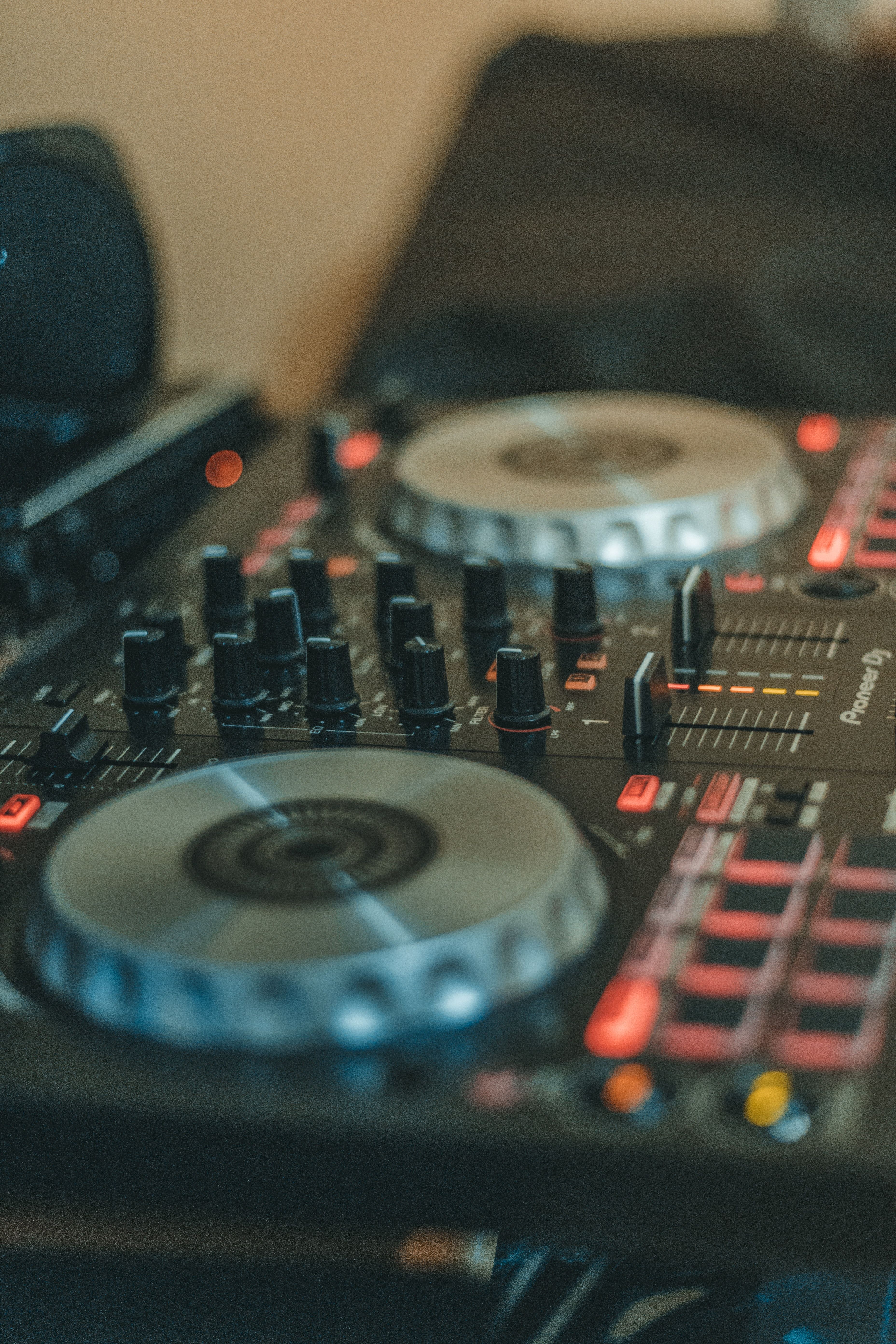 DJ-Controller, Jogwheels, Fader, Nahaufnahme, Warmes Licht, QHD+, iPhone-Hintergrundbild