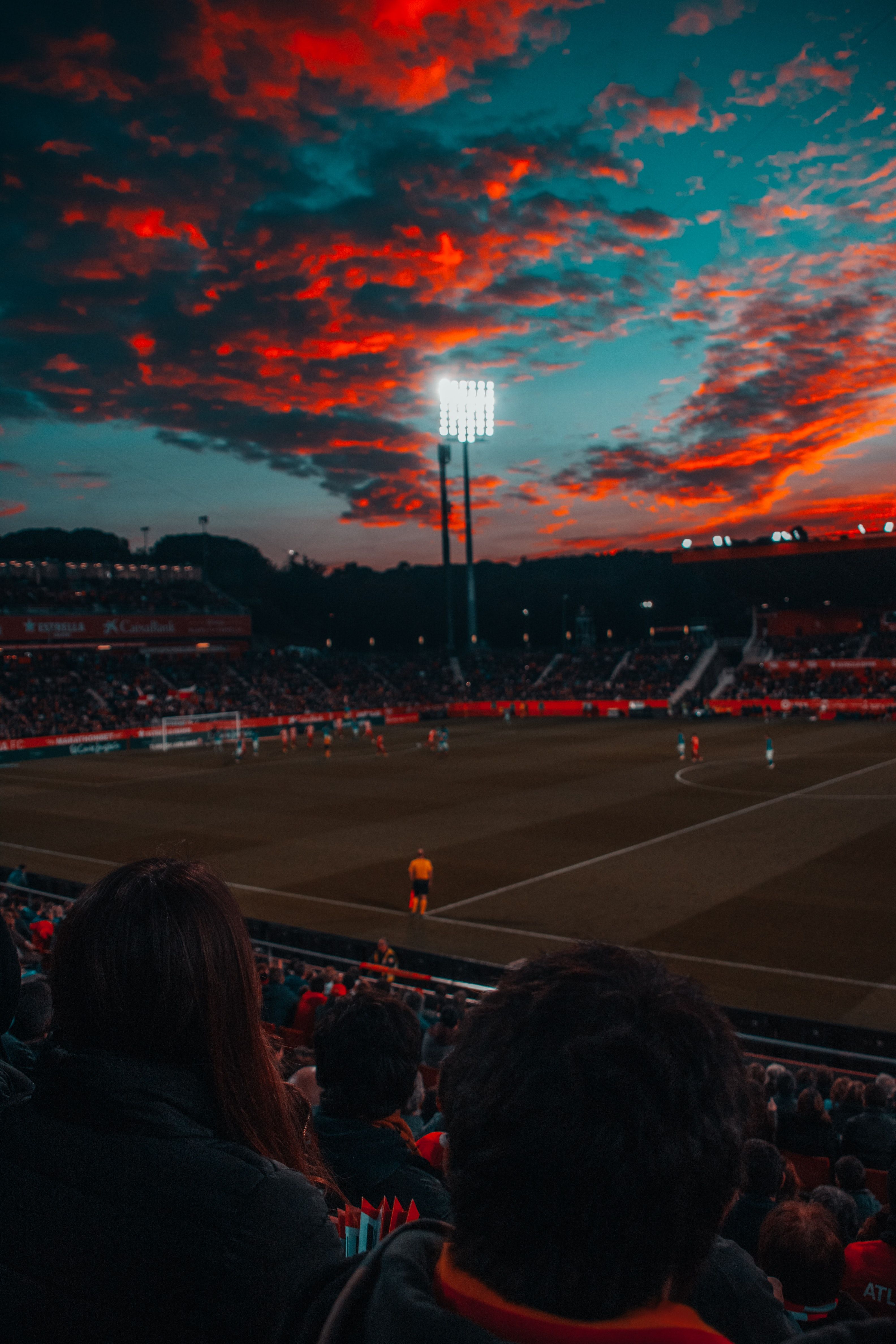 Stadion, Flutlicht, Rote Wolken, Fans, Abendhimmel, QHD+, Handy-Hintergrund im Hochformat