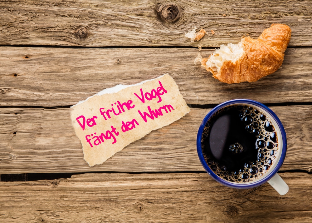 Der frühe Vogel fängt den Wurm, Sprichwort, Kaffee, Croissant, Holztisch, Hintergrundbild