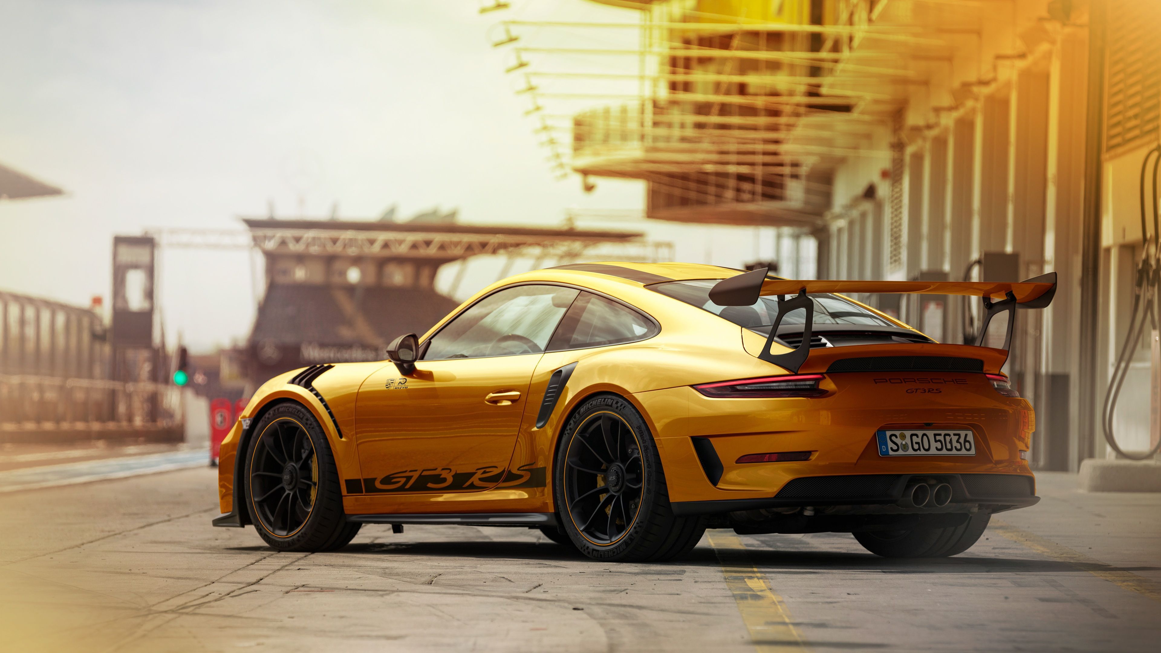 Porsche 911 GT3 RS, Gelber Sportwagen, Boxengasse, Tribüne, Sonnenlicht, 3840x2160, Desktop-Hintergrund