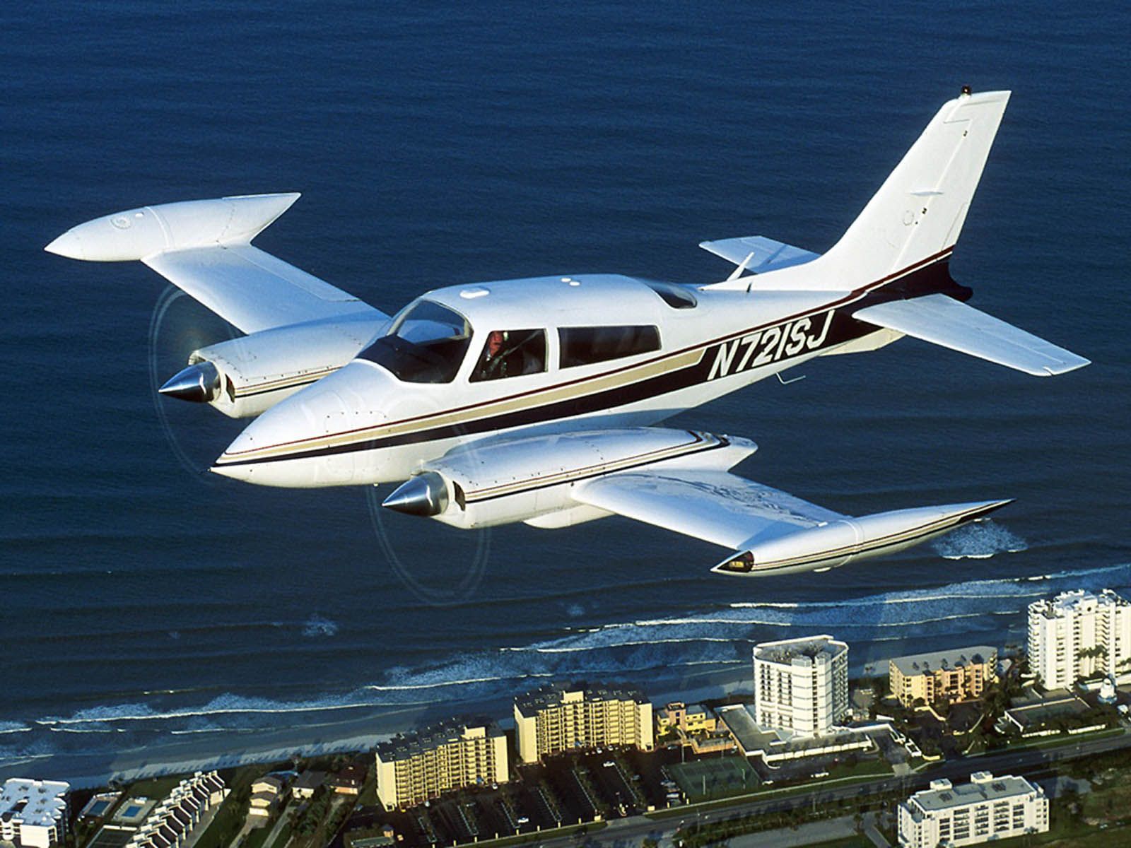 Cessna 310, Zweimotoriges Flugzeug, Im Flug, Küstenstadt, Meer, Hintergrundbild fürs Tablet