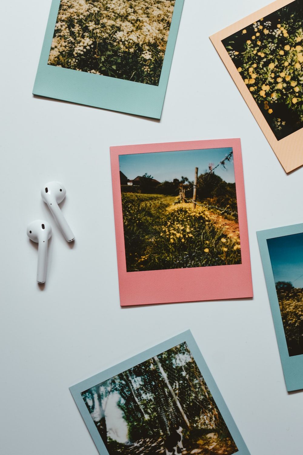 Polaroid-Fotos, AirPods, Natur, Flatlay, Hochformat, Hintergrundbild fürs Smartphone