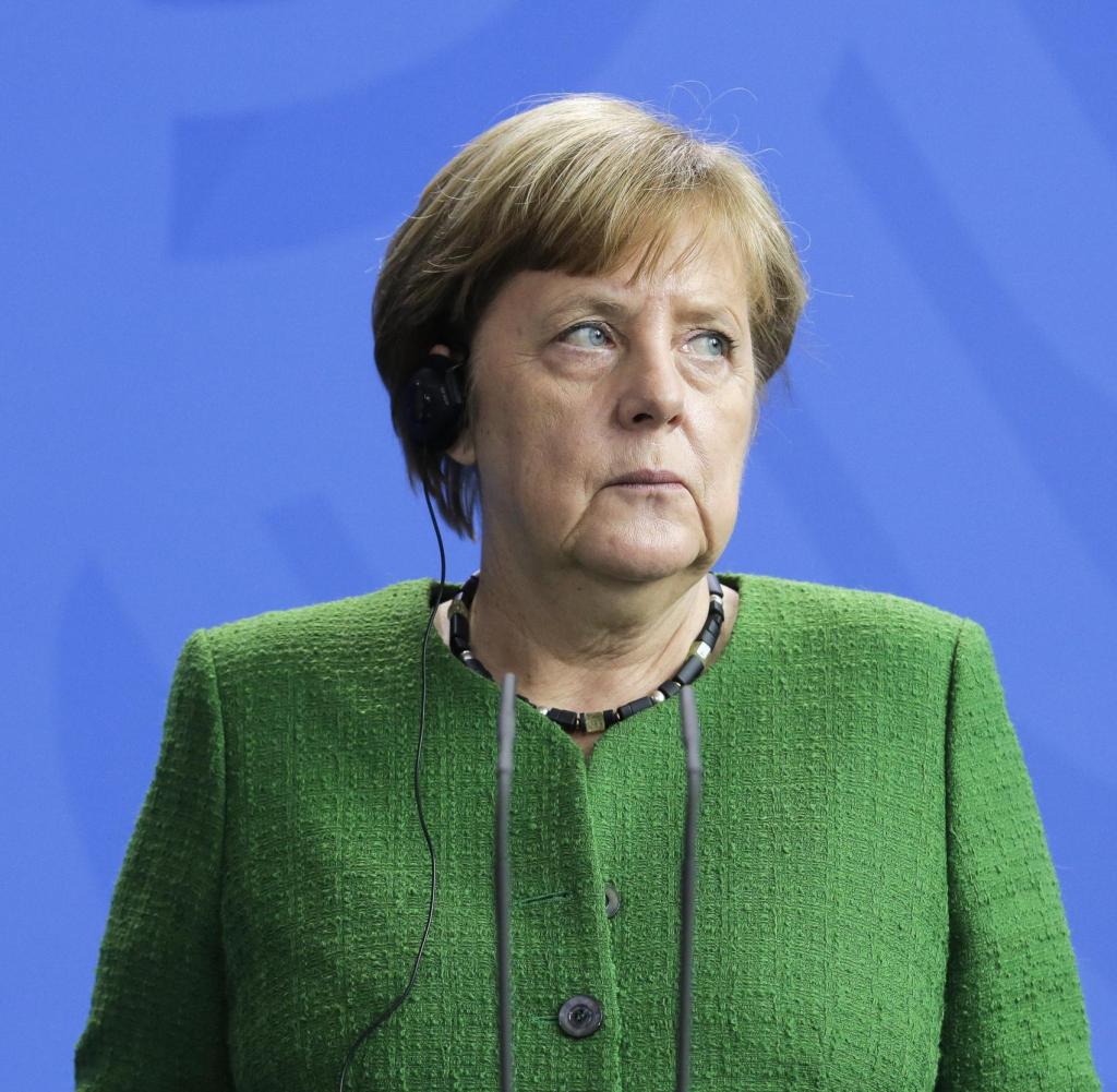 Angela Merkel, Grüne Jacke, Blauer Hintergrund, Ernster Blick, Wallpaper