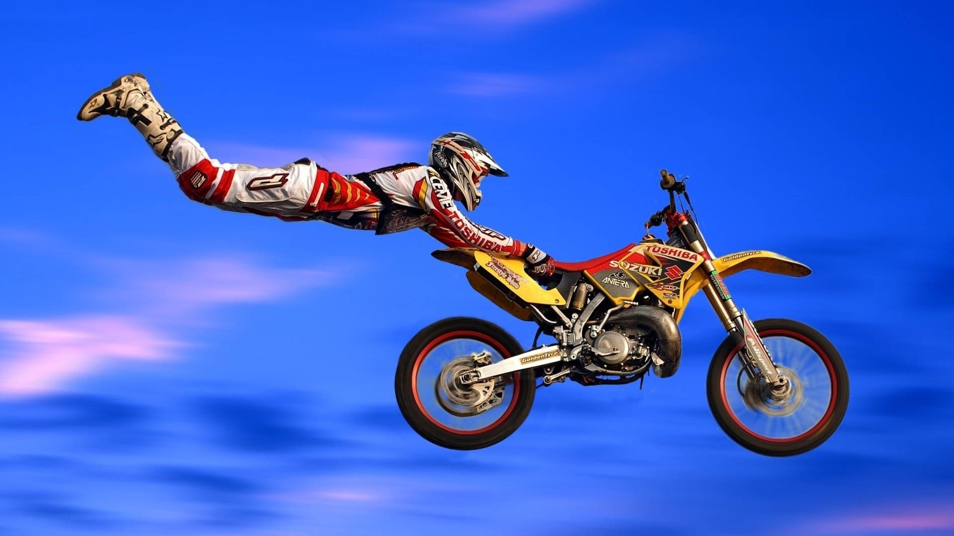 Freestyle-Motocross, Superman-Trick, Stunt, Blauer Hintergrund, Gelbes Motorrad, 1080p Wallpaper